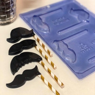 Canudos decorativos com clips de bigode preto e molde azul em superfície clara