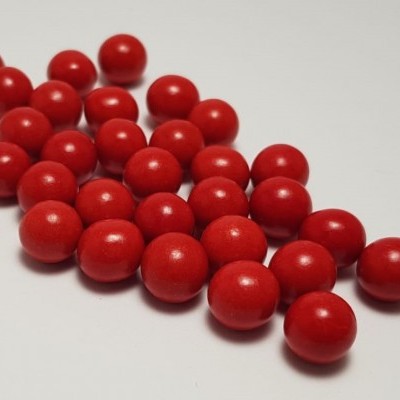 Pequenas esferas vermelhas sobre superfície branca