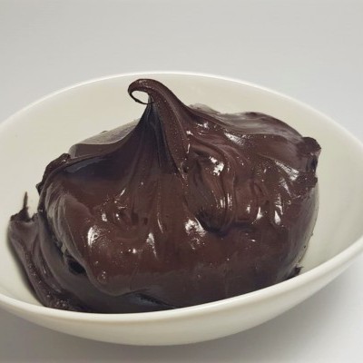 Recipiente branco com creme de chocolate escuro cremoso