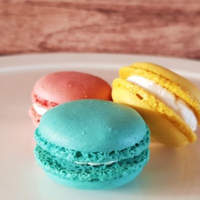 Três macarons coloridos num prato branco