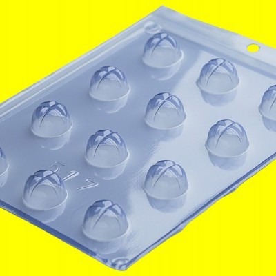 Embalagem plástica transparente com cavidades redondas sobre fundo amarelo.