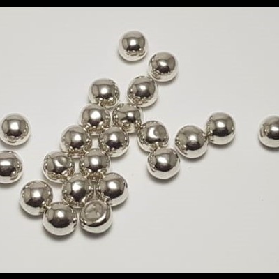Pequenas esferas metálicas prateadas brilhantes sobre fundo branco