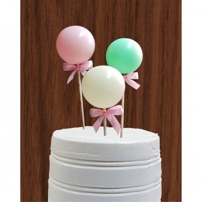 Bolo branco decorado com três balões coloridos com laços rosa