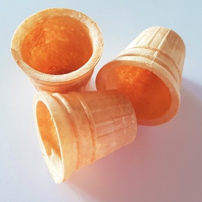 Três copos para gelado do tipo corneta de cor bege clara sobre fundo branco