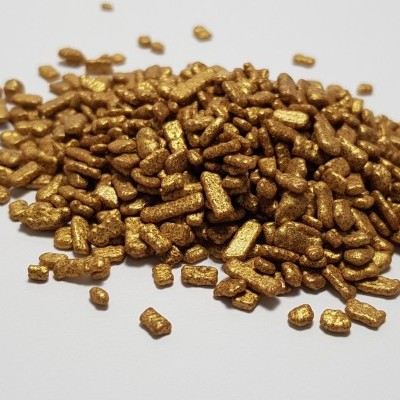 Grânulos dourados pequenos sobre superfície branca