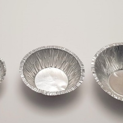 Três formas descartáveis de alumínio de tamanhos variados sobre fundo branco.