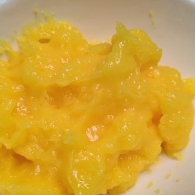 Tigela branca com purê amarelo cremoso.