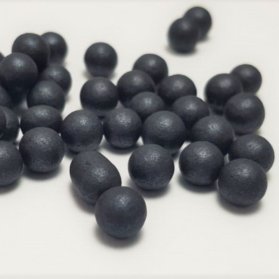 Pequenas esferas pretas sobre superfície branca