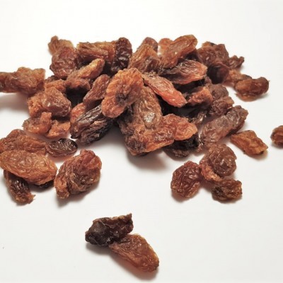 Uvas passas castanhas secas com textura enrugada sobre fundo branco