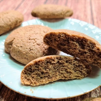 Biscoitos castanhos crocantes num prato azul claro sobre mesa rústica de madeira