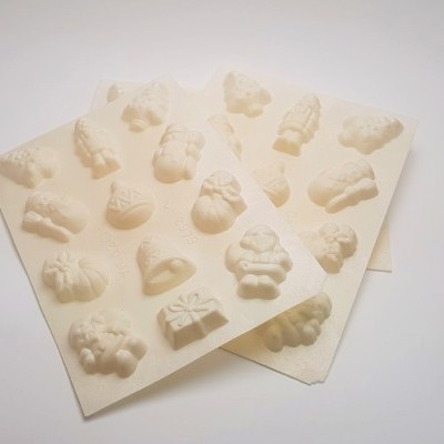 Folhas de papel branco com moldes em relevo de temas natalícios