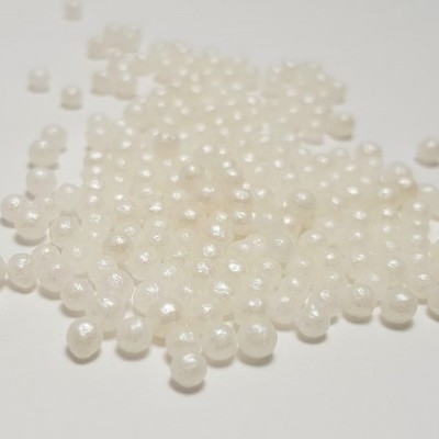 Pequenas pérolas brancas sobre fundo branco