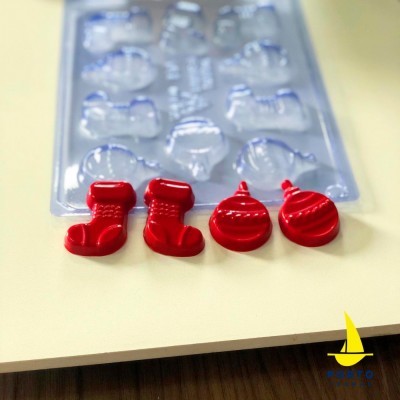 Molde de silicone transparente com chocolates vermelhos de Natal em forma de botas e bolas
