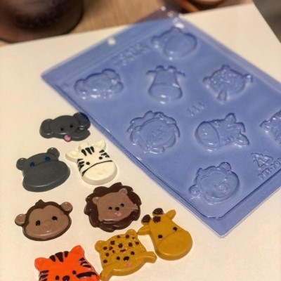 Molde azul de silicone com animais e figuras acabadas coloridas de animais sobre mesa