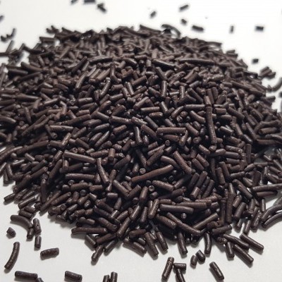 Grânulos cilíndricos de chocolate preto sobre fundo branco