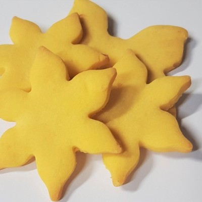 Bolachas amarelas em forma de flor ou estrela sobre fundo branco