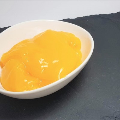 Taça branca com creme amarelo brilhante sobre ardósia preta