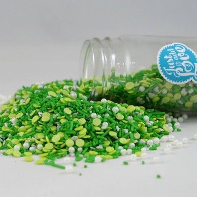 Frasco de vidro com granulado colorido espalhado em tons de verde, amarelo claro e branco