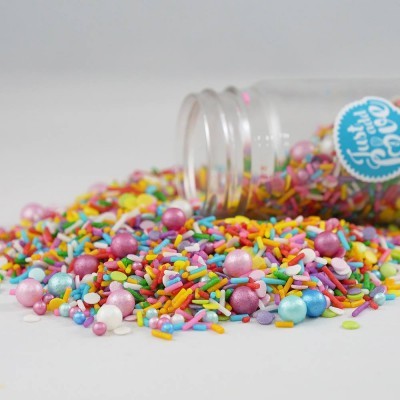 Frasco de confeites coloridos virado com granulados e pérolas espalhados.