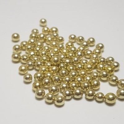 Muitas pequenas pérolas douradas redondas brilhantes em fundo branco