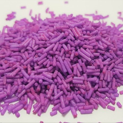 Granulados roxos de confeitaria sobre superfície branca