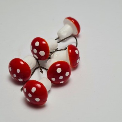 Cogumelos decorativos vermelhos com pontos brancos sobre fundo branco