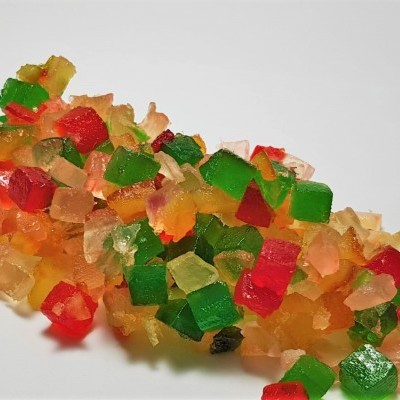 Frutas cristalizadas coloridas empilhadas sobre superfície branca