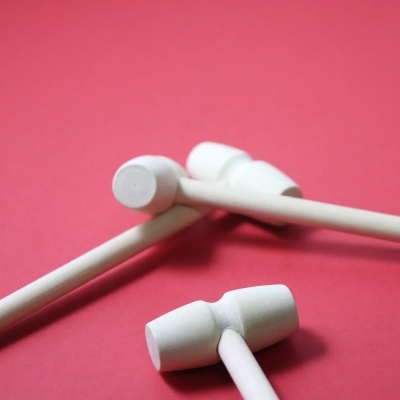 Três paus de madeira brancos sobre fundo rosa