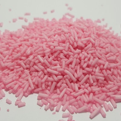 Grânulos pequenos cor de rosa sobre superfície branca