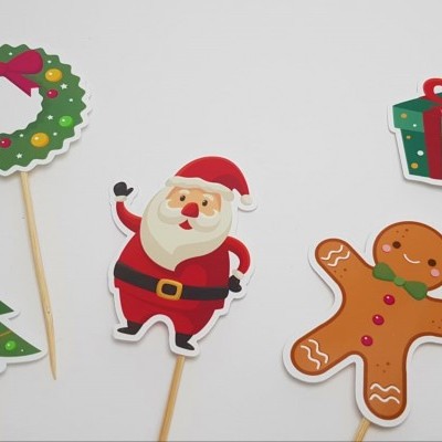 Placas ilustradas de Natal em pauzinhos com árvore, coroa, Pai Natal, biscoito de gengibre e presentes.