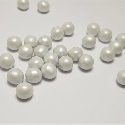 Várias pérolas brancas pequenas e redondas sobre superfície branca