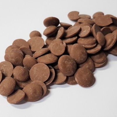 Pastilhas de chocolate redondas castanhas claras sobre fundo branco