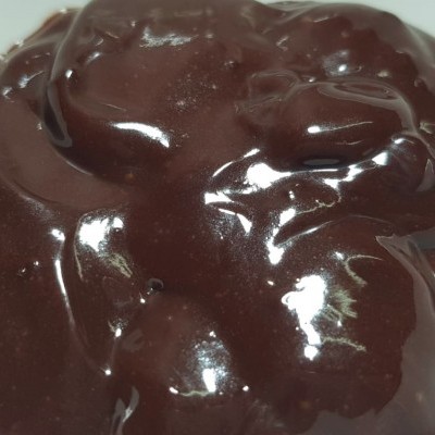 creme espesso castanho escuro com brilho sobre superfície branca