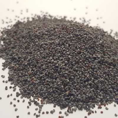 pilha de sementes escuras redondas sobre superfície branca