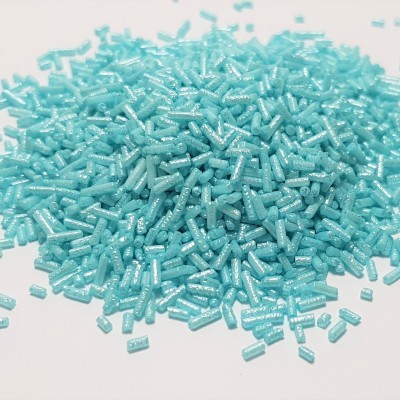Granulados plásticos azuis claros em superfície branca