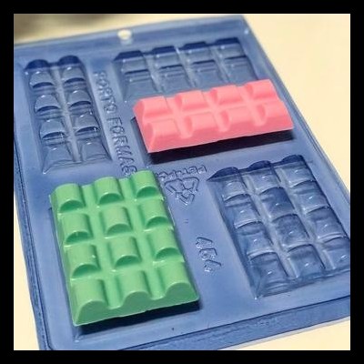 Forma para chocolate azul com chocolates rosa e verde moldados