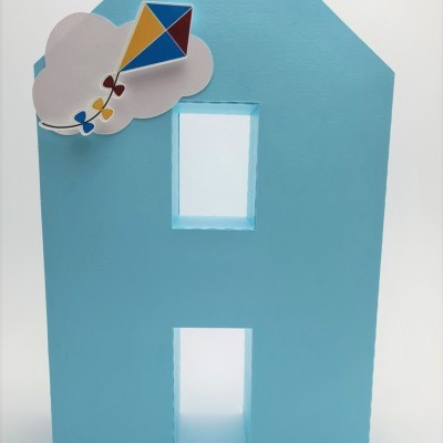 Objeto decorativo em forma de casa azul claro com balão colorido