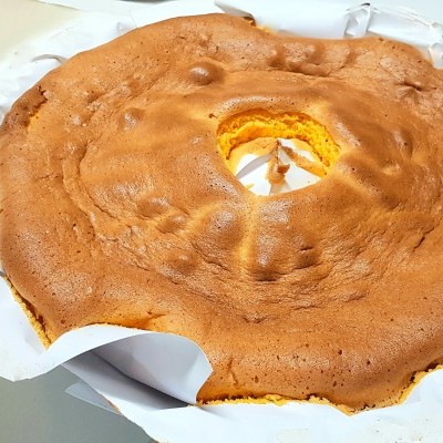 Bolo redondo com buraco no meio sobre papel vegetal branco