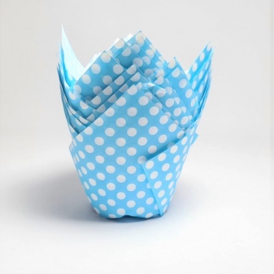 Toalhete de papel azul com bolinhas brancas dobrado decorativamente