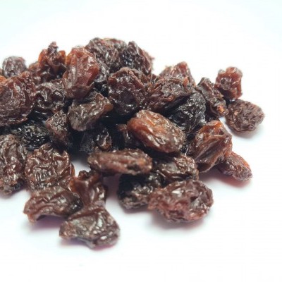 Uvas passas escuras num monte sobre fundo branco