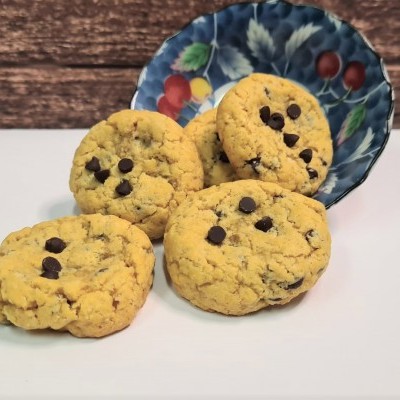 Quatro bolachas com chocolate em prato decorado sobre superfície branca