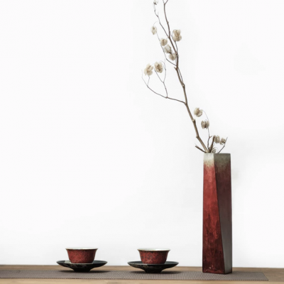 Conjunto de chá e vaso decorativo com ramo seco sobre mesa de madeira