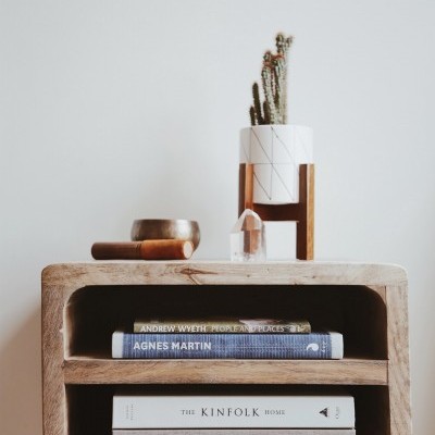 Móvel de madeira com livros e decoração minimalista em cima