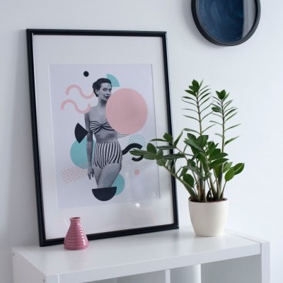 Quadro com imagem estilizada de mulher grávida, vaso de planta e vaso decorativo sobre estante branca