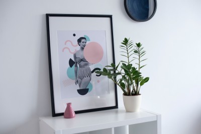 Quadro com imagem estilizada de mulher grávida, vaso de planta e vaso decorativo sobre estante branca