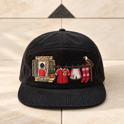 Boné preto com bordado colorido de roupa de futebol pendurada num estendal e boneco na janela
