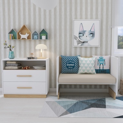 Quarto infantil com móvel branco, estante de parede em formato de casinhas, almofadas decorativas e quadro de gato azul.
