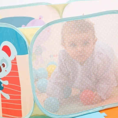 Piscina de bolas infantil com tecido azul e amarelo e criança dentro