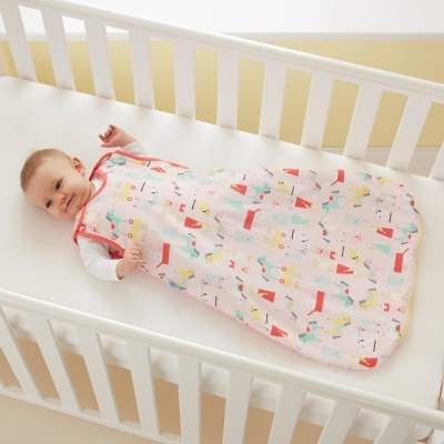 Saco de dormir para bebé colorido num berço branco