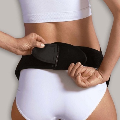 Cinto preto ajustável com fecho de velcro na cintura de uma pessoa com roupa interior branca